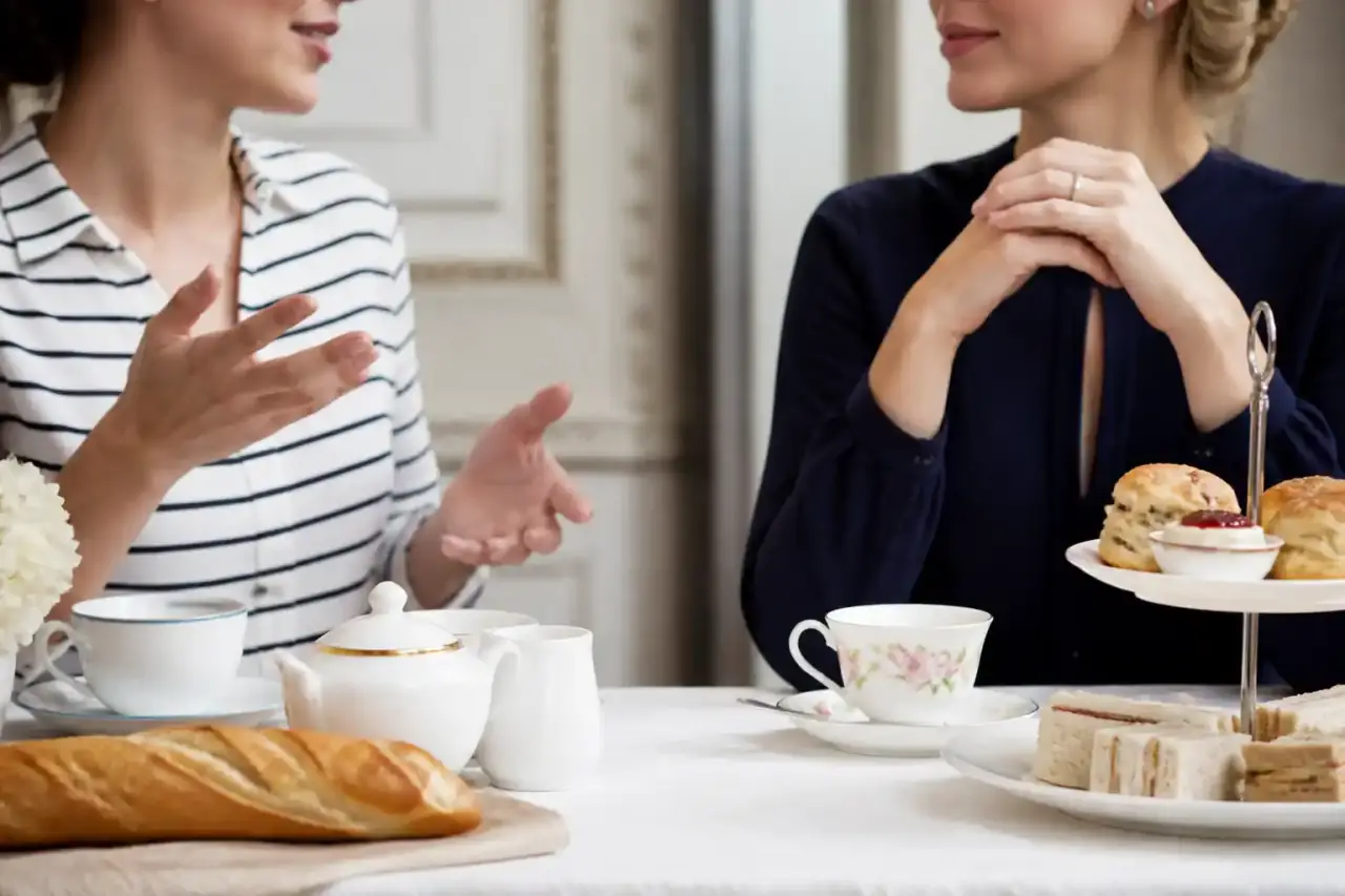 Bureau ancien en bois sombre avec livre relié, tasse de thé et stylo plume